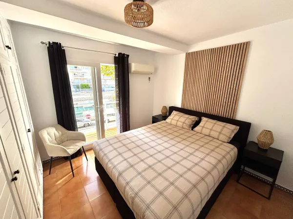 Tweepersoonsbed en stoel in slaapkamer 1